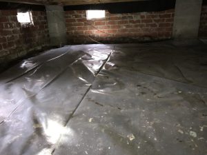 Crawlspace with plastic sheeting for waterproofing, showcasing moisture control solutions relevant to basement repair and waterproofing services.