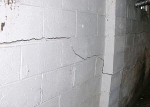 Cracked foundation wall indicating structural damage and potential risk of collapse.