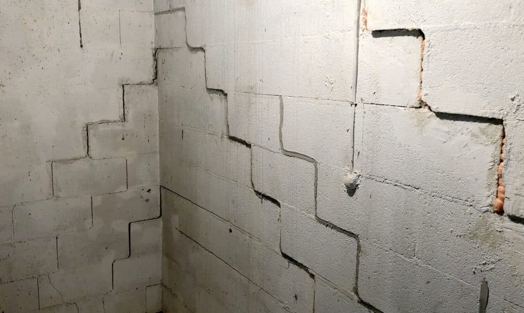 Cracked concrete basement walls indicating potential foundation issues, relevant to foundation repair solutions and structural integrity.