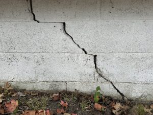 Cracked foundation wall with visible damage, highlighting potential structural issues and the need for timely repairs to maintain home integrity.