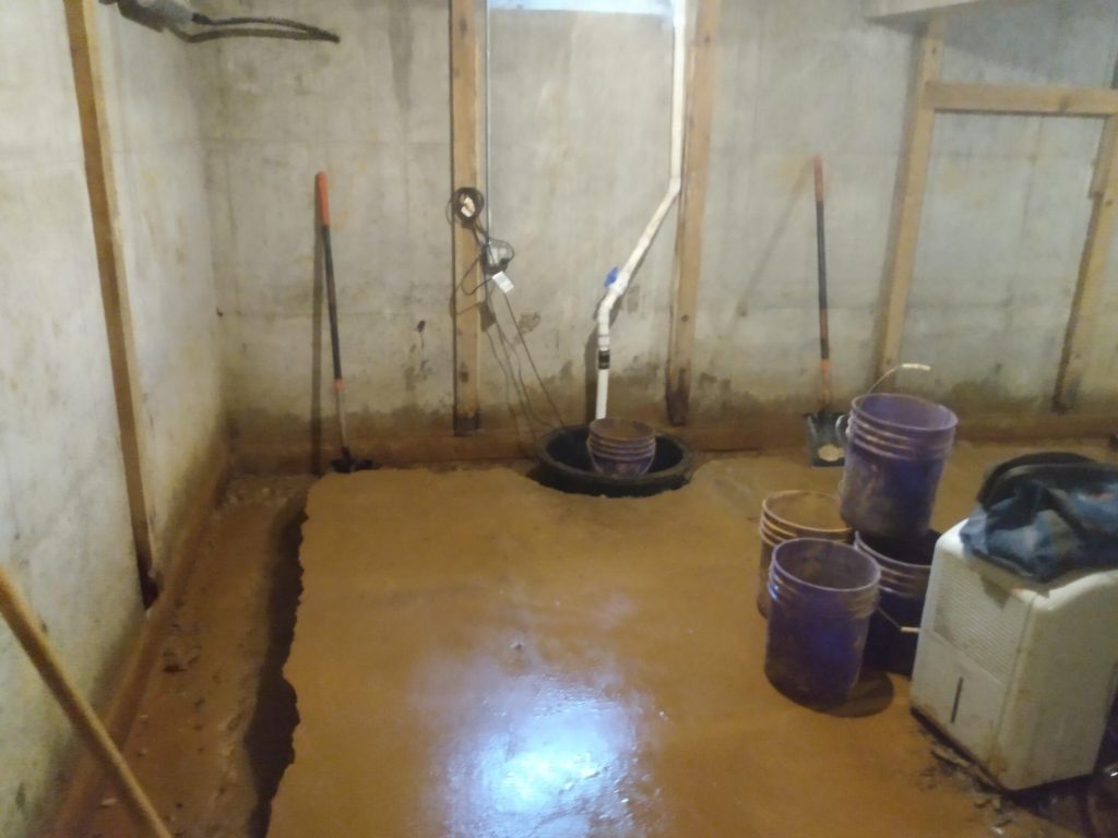 Expert Advice: How to Fix a Leaky Basement Fast Interior basement scene with wet concrete floor, sump pump installation, and tools for basement waterproofing and repair, highlighting the process of addressing basement leaks.