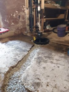 Basement waterproofing setup with sump pump and gravel drainage, highlighting crucial repair elements for preventing water damage and enhancing property value.