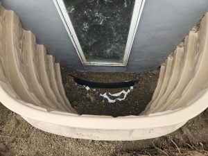 basement egress window well installed outside foundation providing emergency exit and natural light